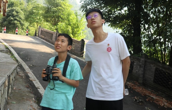 服务团成员带领小朋友户外观鸟。beat365在线体育官网登录入口供图