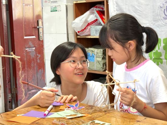 图为志愿者带领小学生制作昆虫相关的手工作品。主办方供图